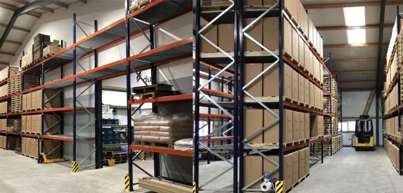 overzicht van gebruikte magazijnstellingen met huftruck op de achtergrond